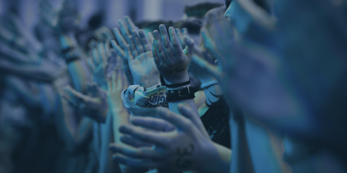 A crowd clapping with a navy blue overlay